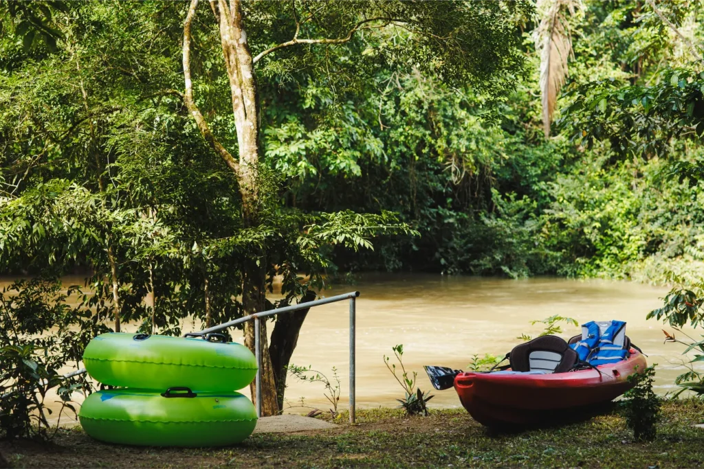River tubing and kayaking equipment on the edge of a tropical river at Tanager Rainforest Lodge.